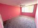 Bedroom features carpet and pink walls with a window at 4823 Ebbtide Ln # 105, Port Richey, FL 34668
