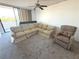 Living room featuring a ceiling fan, sectional sofa, recliner, and sliding glass door at 4823 Ebbtide Ln # 105, Port Richey, FL 34668