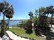 Water view overlooking the lawn with palms and a peek at the docks and boats on a sunny day at 4823 Ebbtide Ln # 105, Port Richey, FL 34668
