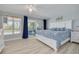 Bright main bedroom features light wood floors, ceiling fan, and access to the lanai with water views at 4917 Marlin Dr, New Port Richey, FL 34652