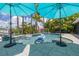 Inviting pool area with clear water, blue umbrellas, and lush tropical landscaping at 4917 Marlin Dr, New Port Richey, FL 34652