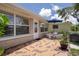 Charming back patio with a brick exterior, patterned tile, and outdoor seating area, ideal for entertaining at 4937 Dory Dr, New Port Richey, FL 34652
