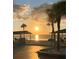 Scenic sunset view of the beach featuring palm trees and picnic shelters at 4937 Dory Dr, New Port Richey, FL 34652