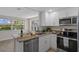 A kitchen with stainless steel appliances and countertops, and granite bar top at 4937 Dory Dr, New Port Richey, FL 34652