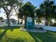 Well-maintained lawn area with palm trees and a 'Private Beach Club' sign on a chair at 4937 Dory Dr, New Port Richey, FL 34652