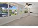 Inviting sunroom with tile floors, ceiling fan, and windows showcasing the lovely backyard and waterfront at 4937 Dory Dr, New Port Richey, FL 34652