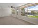 Bright sunroom featuring tile floors, ceiling fan, and panoramic windows with scenic waterfront views at 4937 Dory Dr, New Port Richey, FL 34652