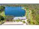 Breathtaking aerial view of the community lake and clubhouse with lush trees and greenery at 5001 Night Star Trl, Odessa, FL 33556