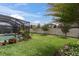 Backyard with a screened pool, a well-maintained lawn, and colorful flowers in the landscaping at 5001 Night Star Trl, Odessa, FL 33556