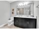 Modern bathroom featuring double sinks, framed mirror, and a tiled shower with glass door at 5001 Night Star Trl, Odessa, FL 33556