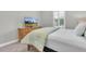 Cozy bedroom featuring a dresser with TV, plantation shutters and soothing light at 5001 Night Star Trl, Odessa, FL 33556