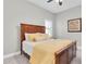 Bright bedroom featuring a wooden bed frame and a window with plantation shutters at 5001 Night Star Trl, Odessa, FL 33556