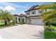 Elegant two-story home featuring a stone facade, three-car garage, and beautifully landscaped front yard at 5001 Night Star Trl, Odessa, FL 33556
