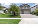 Charming home with a three-car garage, beautifully landscaped front yard, and well-manicured lawn at 5001 Night Star Trl, Odessa, FL 33556