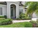 Charming front entrance with a decorative glass door, manicured landscaping and a welcoming walkway at 5001 Night Star Trl, Odessa, FL 33556