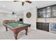 The game room boasts a pool table, a wet bar, a ceiling fan, and a sectional sofa at 5001 Night Star Trl, Odessa, FL 33556