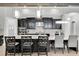 Modern kitchen with black cabinetry, stainless steel appliances, pendant lighting, and a large center island with seating at 5001 Night Star Trl, Odessa, FL 33556