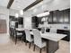 Modern kitchen features high ceilings, wooden beams, stainless steel appliances, and a large center island with seating at 5001 Night Star Trl, Odessa, FL 33556