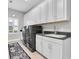 Bright laundry room with white cabinets, gray countertop and new washer and dryer at 5001 Night Star Trl, Odessa, FL 33556