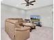 The living room offers a leather sofa, ceiling fan, white brick wall and a television at 5001 Night Star Trl, Odessa, FL 33556