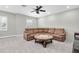 The living room features a leather sectional, a ceiling fan, and a white brick accent wall at 5001 Night Star Trl, Odessa, FL 33556