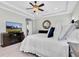 The spacious main bedroom boasts a tray ceiling, ceiling fan, and a television at 5001 Night Star Trl, Odessa, FL 33556