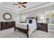 This main bedroom features dark wood furniture, a ceiling fan and a tray ceiling at 5001 Night Star Trl, Odessa, FL 33556