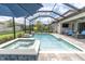 Relaxing screened-in pool and spa with lush landscaping, comfortable seating, and outdoor television at 5001 Night Star Trl, Odessa, FL 33556