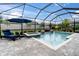 Screened-in pool area featuring a private pool, jacuzzi and lounge chair with a backyard view at 5001 Night Star Trl, Odessa, FL 33556
