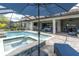 Beautiful screened-in pool and spa with lush landscaping and comfortable outdoor seating at 5001 Night Star Trl, Odessa, FL 33556
