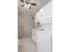 Bathroom with a tiled walk-in shower, marble countertop, and a stacked washer and dryer set at 5045 Pelican Dr, New Port Richey, FL 34652