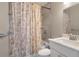 Bathroom with a shower and bathtub, marble-top vanity and toilet with patterned shower curtain at 5045 Pelican Dr, New Port Richey, FL 34652