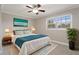 Comfortable bedroom with a queen-sized bed, turquoise accents, a ceiling fan, and a sunny window at 5045 Pelican Dr, New Port Richey, FL 34652