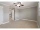 Simple bedroom features tile flooring, neutral paint, a ceiling fan, and an open doorway at 5045 Pelican Dr, New Port Richey, FL 34652