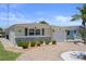 View of the home's front exterior showcasing stone accents, updated shutters, and a brick driveway at 5045 Pelican Dr, New Port Richey, FL 34652