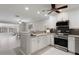 Open kitchen with white cabinets, granite countertops, stainless steel appliances, and a breakfast bar at 5045 Pelican Dr, New Port Richey, FL 34652