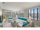 Bright living room with white wicker furniture, turquoise cushions, and ample natural light from large windows at 5045 Pelican Dr, New Port Richey, FL 34652