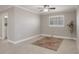 Neutral living room features tile flooring, a ceiling fan, and a decorative rug with a view into an adjacent room at 5045 Pelican Dr, New Port Richey, FL 34652