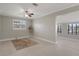 Bright living area with neutral paint, tile flooring, ceiling fan, and an adjacent space through an arched doorway at 5045 Pelican Dr, New Port Richey, FL 34652