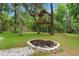 A cozy fire pit and custom-built backyard playhouse invite outdoor entertainment and relaxation at 5487 Valley View Dr, Brooksville, FL 34601