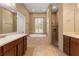 The luxurious bathroom features a soaking tub, a separate shower, and double sink vanity with wood cabinets at 5487 Valley View Dr, Brooksville, FL 34601