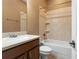Functional bathroom featuring a bathtub, a single sink vanity with wood cabinets, and neutral tile flooring at 5487 Valley View Dr, Brooksville, FL 34601