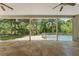 Relaxing covered patio offers peaceful views of the pool, fenced backyard, and surrounding mature trees and greenery at 5487 Valley View Dr, Brooksville, FL 34601