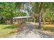 This large garage features a covered parking area and ample storage space, nestled among mature trees at 5487 Valley View Dr, Brooksville, FL 34601