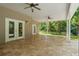 Large covered patio with tile floors overlooking a backyard with mature trees and a playset at 5487 Valley View Dr, Brooksville, FL 34601