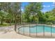 Backyard featuring a refreshing in-ground pool with a safety fence, surrounded by lush greenery at 5487 Valley View Dr, Brooksville, FL 34601
