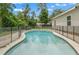 Inviting pool with safety fence is surrounded by lush landscaping and mature trees for added privacy at 5487 Valley View Dr, Brooksville, FL 34601