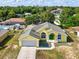 Charming yellow single-story home featuring a green front door, lush landscaping, and attached garage at 6028 Dorset Rd, Spring Hill, FL 34608