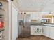 This kitchen features stainless steel appliances, white cabinets, and tile floors at 6028 Dorset Rd, Spring Hill, FL 34608
