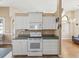This kitchen includes modern appliances, white cabinetry and an electric range at 6028 Dorset Rd, Spring Hill, FL 34608